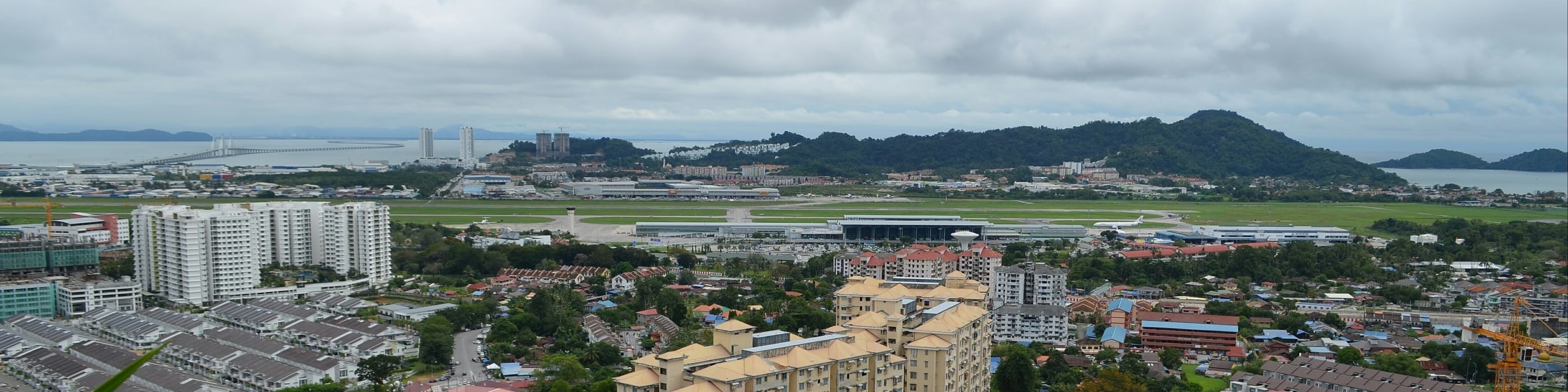 Panorama south across Bayan Lepas: the airport runway in the middle, the Second Penang Bridge running out to sea on the left and the south-east hills beyond